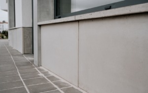Betonový parapet a spodní fasádní obklad polyfunkční budovy.