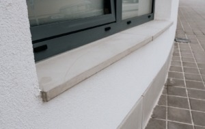 Detail betonového parapetu pod oknem u polyfunkčního domu ve Šlapanicích.