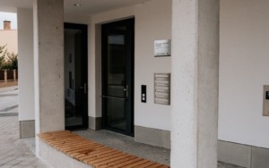 Detail hladkého pohledového betonového sloupu u vstupu polyfunkčního domu ve Šlapanicích.