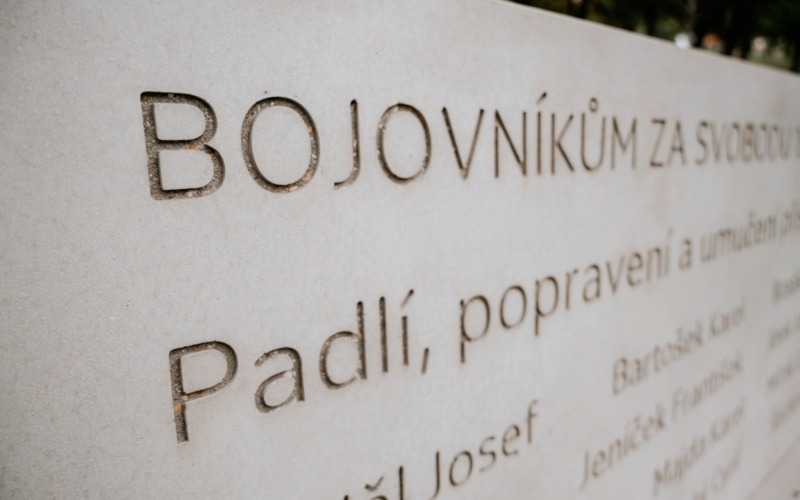 Detail prohloubeného nápisu Bojovníkům za svobodu na betonové pamětní stěně.