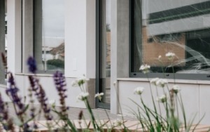 betonové obklady fasády s výsadbou v popředí – polyfunkční dům Šlapanice