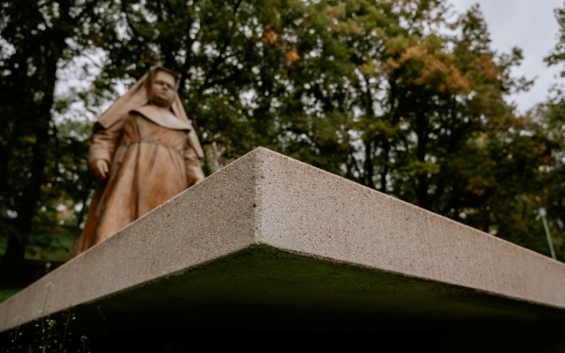 Socha Marie Restituty na štíhlém betonovém podstavci z pohledového betonu.